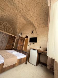a bedroom with a bed and a desk and a tv at Rocinante House in Mardin +70 photos