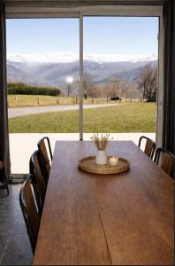 a dining room table with a view of the mountains at Villa MYRTILLE classée 4 étoiles meublé de tourisme - Vue montagne, terrasse, jardin, 8 pers in Murat-le-Quaire