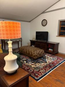 a living room with a television and a table with a lamp at The Cabin at Skyfall Country Estate in Polokwane