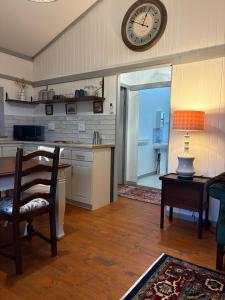 a kitchen with a table and a clock on the wall at The Cabin at Skyfall Country Estate in Polokwane