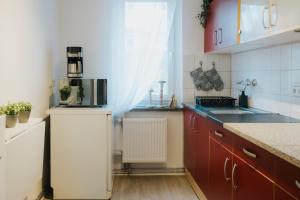 a kitchen with red cabinets and a white refrigerator at Monteurwohnung Spremberg in Spremberg