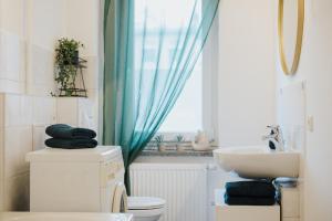 a bathroom with a toilet and a sink and a window at Monteurwohnung Spremberg in Spremberg