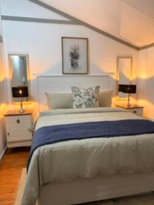 a bedroom with a large bed and two lamps at The Cabin at Skyfall Country Estate in Polokwane