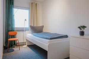 a bed in a room with a window and a chair at Monteurwohnung Spremberg in Spremberg