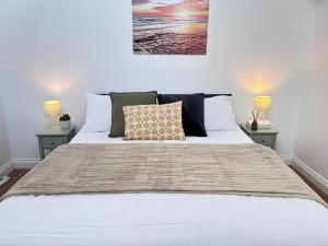 a bedroom with a large white bed with two lamps at 4 Bed Contractor Apartment with Parking Central Banbury in Banbury