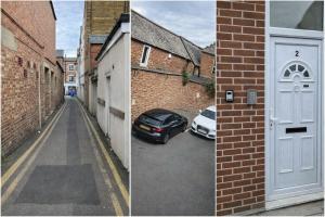 a car parked in a parking lot next to a white door at 4 Bed Contractor Apartment with Parking Central Banbury in Banbury
