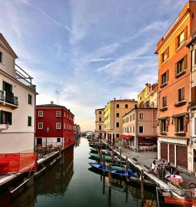 a canal in a city with buildings and boats at el Capitan de Mar in Chioggia