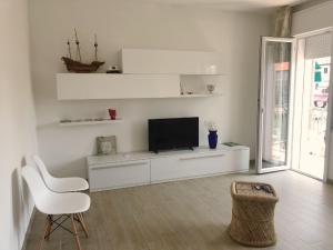 a living room with a television and a white chair at el Capitan de Mar in Chioggia