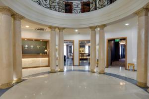 a large lobby with columns and a ceiling at Hotel Astoria Tbilisi in Tbilisi City +57 photos