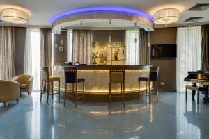 a bar in a room with chairs and a table at Hotel Astoria Tbilisi in Tbilisi City