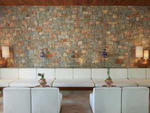 ein Wohnzimmer mit einer Couch und einer Backsteinwand in der Unterkunft Amirandes, A Resort to Live in Gouves