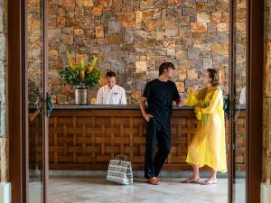 Ein Mann und eine Frau stehen an einem Tresen in der Unterkunft Amirandes, A Resort to Live in Gouves