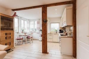 a kitchen with white cabinets and a table at HarzZeitRaum in Thale