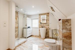 a bathroom with a toilet and a shower at HarzZeitRaum in Thale +28 photos