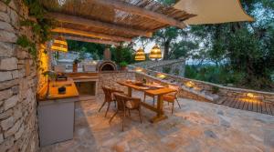an outdoor kitchen with a table and chairs on a patio at Lucié in Argyrátika