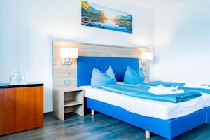 a bedroom with a bed with a blue headboard at Hotel Casa Maria in Halblech +37 photos