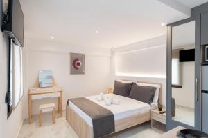 ein kleines Schlafzimmer mit Bett und Schreibtisch in der Unterkunft Anassa Suites 3 in Iraklio