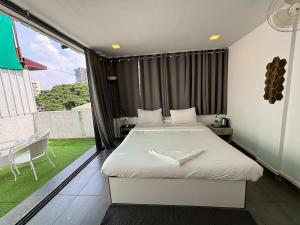 a bedroom with a bed and a large window at Sunleaf Palace in Pune