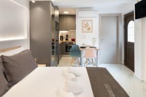 ein Schlafzimmer mit einem weißen Bett und eine Küche in der Unterkunft Anassa Suites 3 in Iraklio