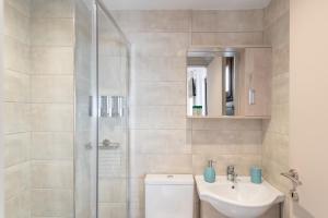 ein Badezimmer mit Dusche, Waschbecken und Toilette in der Unterkunft Anassa Suites 3 in Iraklio