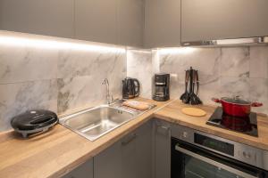 eine Küchenarbeitsplatte mit Spüle und Herd in der Unterkunft Anassa Suites 3 in Iraklio