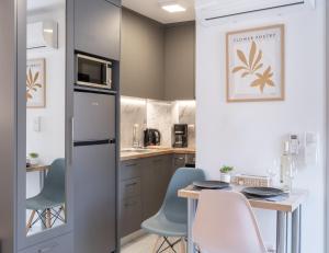 eine Küche mit Tisch, Stühlen und Kühlschrank in der Unterkunft Anassa Suites 3 in Iraklio