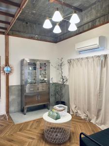 a living room with a table and a cabinet at お宿イヌとネコと in Shima