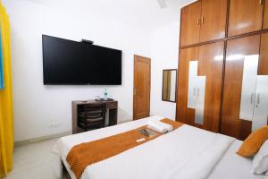 a hotel room with a bed and a flat screen tv at Mauryan Express I Hotel Malviya Nagar in New Delhi
