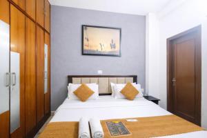 a bedroom with a bed and a picture on the wall at Mauryan Express I Hotel Malviya Nagar in New Delhi
