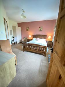 a bedroom with a large bed and a desk at Deerpark Manor Bed and Breakfast in Swinford