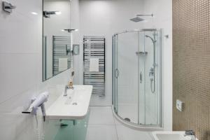 a white bathroom with a sink and a shower at Wenceslas Hotel & Apartments in Prague
