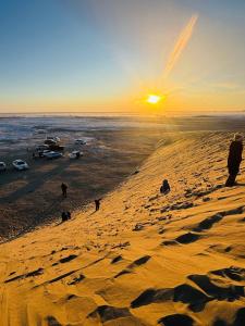 a group of people on a beach at sunset at Mongolian Nomadic Herders in Dörgön +17 photos