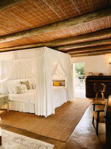 ein Schlafzimmer mit einem weißen Bett und einem Klavier in der Unterkunft Ashbourne Country Escape Hazyview in Hazyview + 159 Fotos