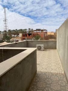 a view of a rooftop with a building in the background at Dar Tozeur in El Oudiane-Degache