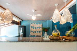 a kitchen with blue walls and a counter with chandeliers at Hotel do Pescador in Morro de São Paulo