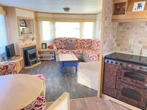 a living room with a couch and a table at PD Wonderwall Caravan, Direct beach access & Beds made on arrival & GCH in Ingoldmells