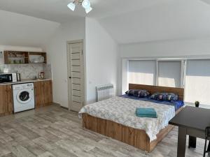 a bedroom with a bed and a table in it at Welcome Hotel in Kostanay