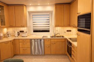 a kitchen with wooden cabinets and a sink and a window at Charmantes Apartment Roding mit 3 Schlafzimmer in Roding