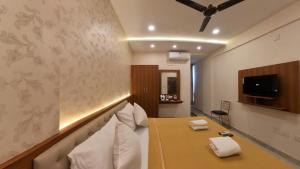 a hotel room with a bed with two towels at UK Comforts in Bangalore