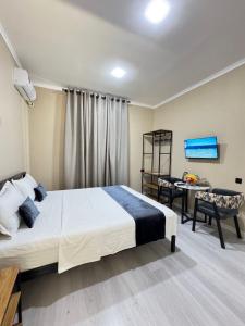 a bedroom with a bed and a desk and a chair at Luna Plaza Hotel in Lunacharskiy Bekati
