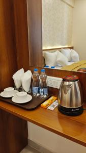a counter with a tea kettle and bottles of water at UK Comforts in Bangalore