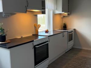 a kitchen with white cabinets and a black counter top at Bryggans Vandrarhem in Västervik +10 photos