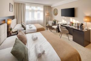 a hotel room with two beds and a desk at Wenceslas Hotel & Apartments in Prague