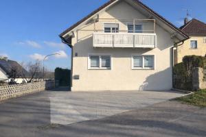 a white house with a balcony on top of it at Charmantes Apartment Roding mit 3 Schlafzimmer in Roding