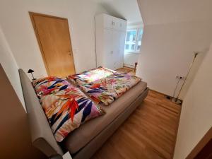 a bed with a colorful blanket on it in a room at Ferienwohnung Bleimuth in Passail
