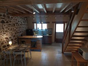 a kitchen and dining room with a table and a staircase at Les puisayennes in Treigny +3 photos
