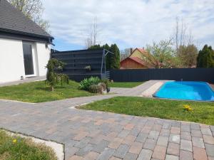 a backyard with a swimming pool next to a house at Silver Gold Anka in Fonyód