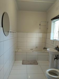 a bathroom with a tub and a toilet and a sink at Five-Bedroom House at 27 Baobab Avenue, Birchleigh, Kempton Park, Backup Power Supply in Kempton Park +37 photos