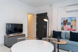 a living room with a blue couch and a tv at Kleoniki Residential Complex in Ofrínion