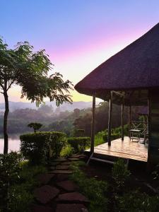 a cabin with a deck and a view of a river at Mwamba Kelele Lodge in Kasenda